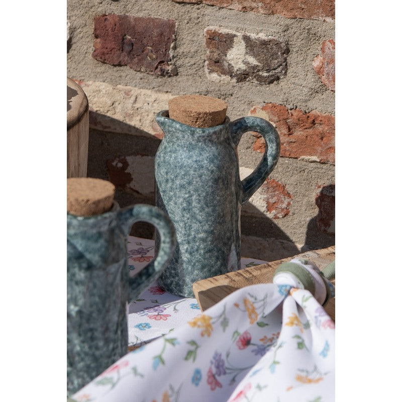 Green ceramic oil and vinegar bottles styled on a table